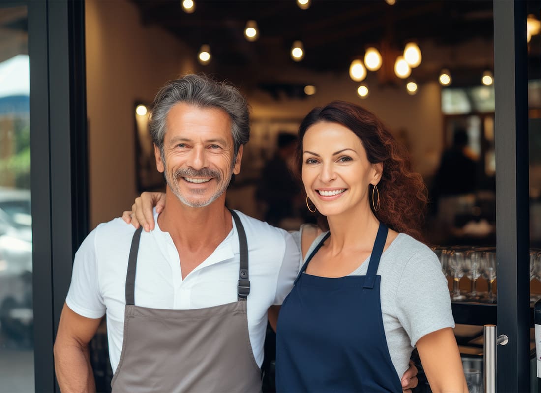 Insurance by Industry - Cheerful Small Business Owners Standing at a Restaurant Entrance