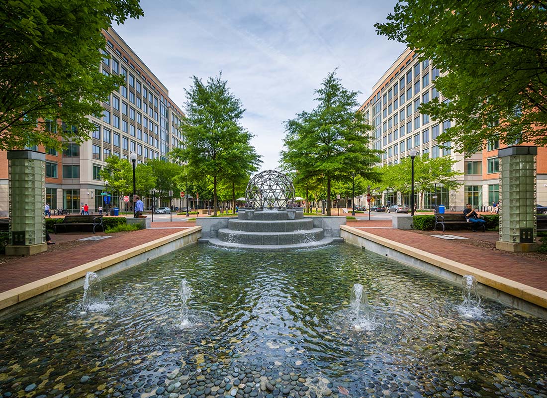 Alexandria, VA - Scenic View of a Coin Fountain Surrounded by Green Trees and Modern Commercial Buildings in Downtown Alexandria Virginia